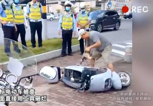 男子骑超标电动车被查后当众砸车